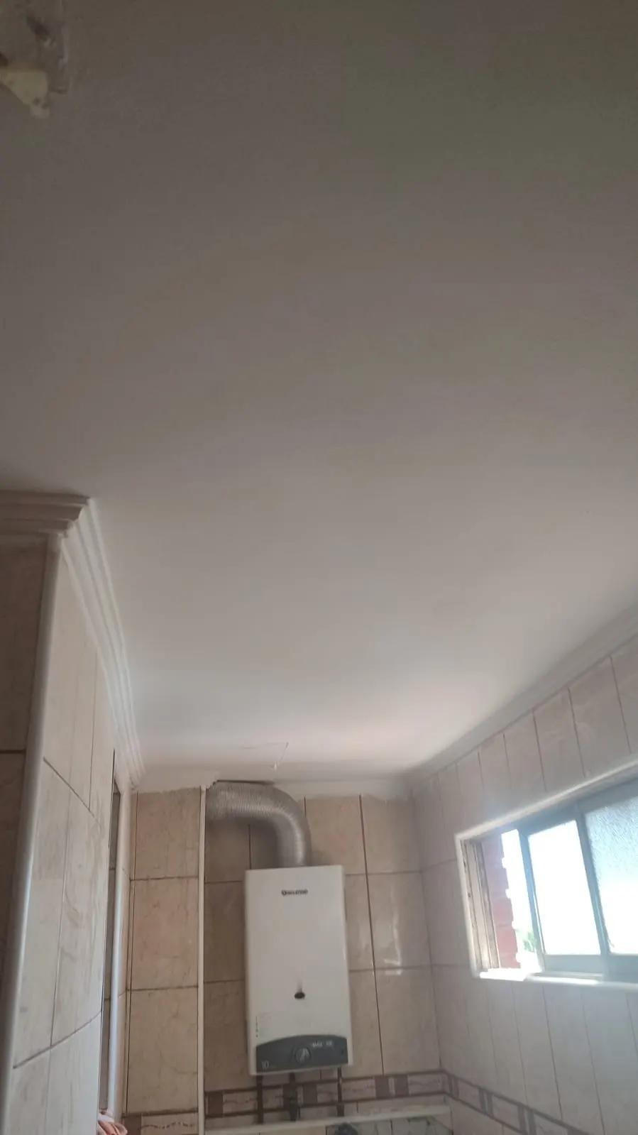 Baño con cerámica y calefont terminado en Las Condes