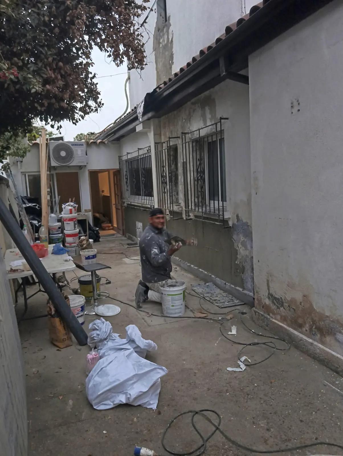 Fachada de casa con humedad antes de reparar y pintar en Providencia